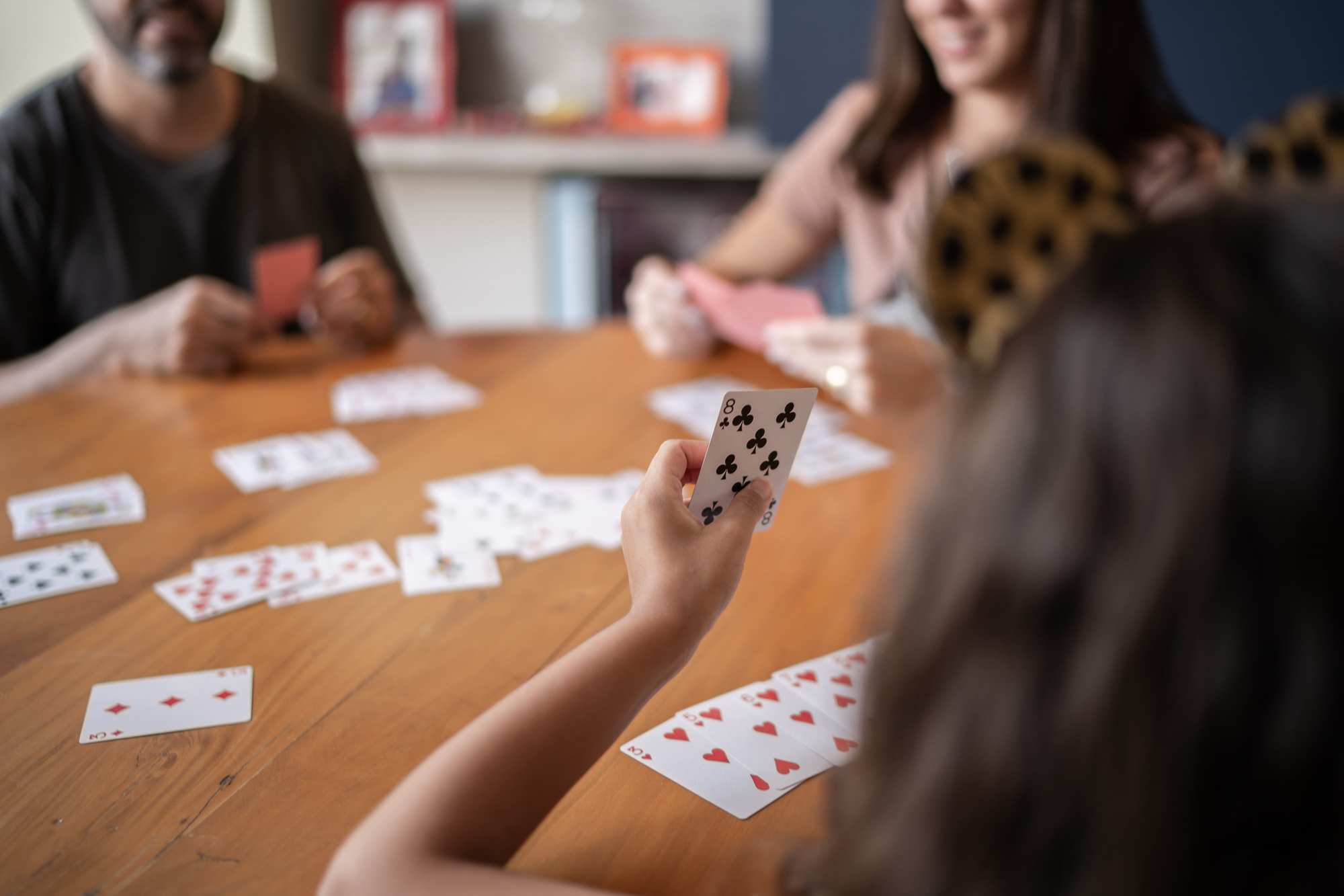 Personer spelar kort vid ett träbord