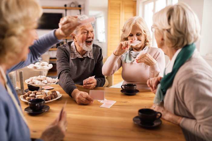 Några äldre kvinnor spelar kort runt ett bord