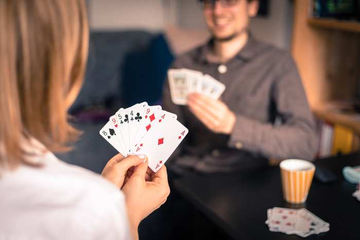 Några kvinnor spelar kort runt ett bord