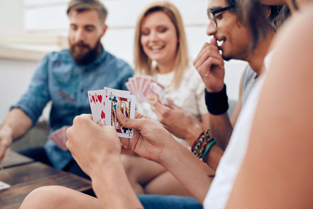 Några kvinnor spelar kort runt ett bord