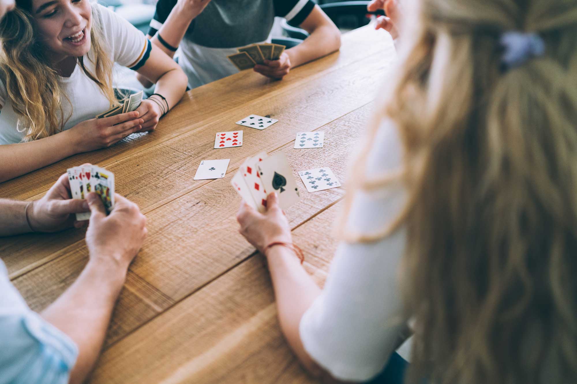 Personer spelar kort vid ett träbord