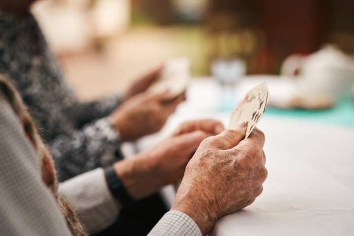 Några kvinnor spelar kort runt ett bord